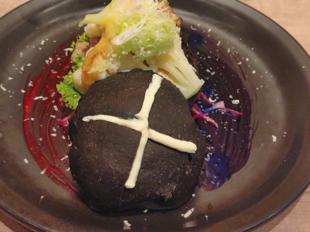 呪術廻戦カフェ2025渋谷事変の五条悟メニュー、西京『最強』味噌サンド。現代最強の術師・五条悟をイメージした西京味噌ソースのポークサンドウィッチで、『蒼』と『赫』を表現したマヨネーズソースが添えられている。