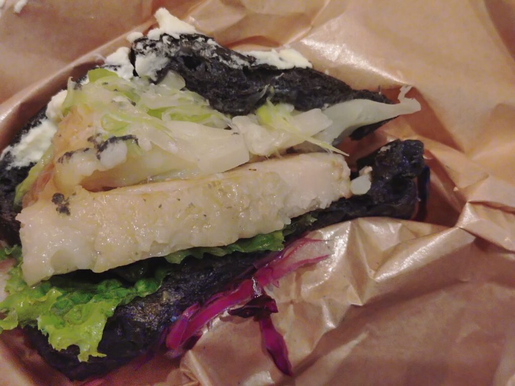 呪術廻戦カフェ2025渋谷事変の五条悟メニュー、西京『最強』味噌サンド。現代最強の術師・五条悟をイメージした西京味噌ソースのポークサンドウィッチで、『蒼』と『赫』を表現したマヨネーズソースが添えられている。