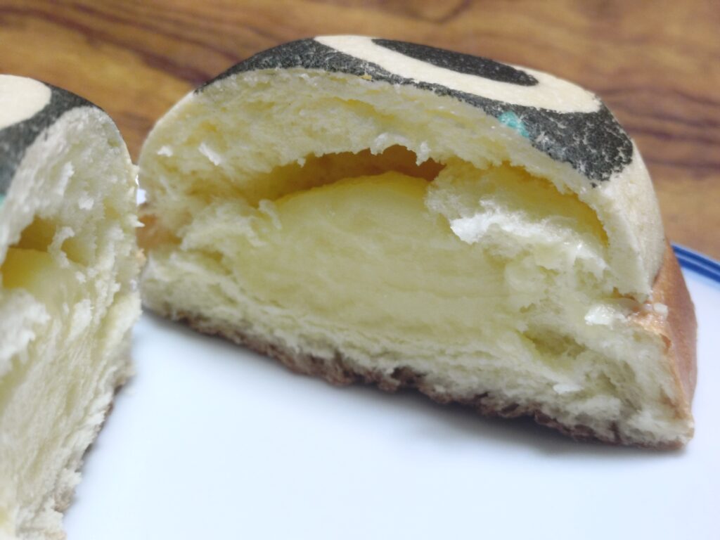 羅小黒戦記2と109シネマズのコラボ商品「シャオヘイパン」を半分にカットした断面写真。生地の食感や中身がわかるように撮影されている。