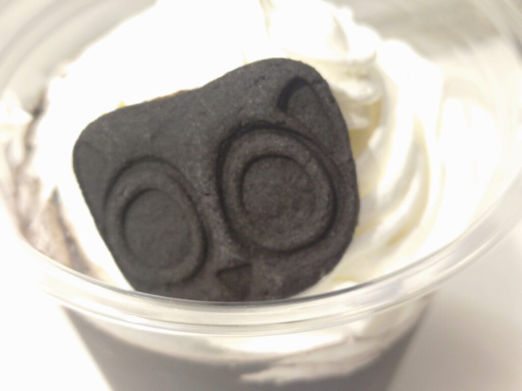 羅小黒戦記2とミッドランドスクエアシネマのコラボ商品、ブラックココアドリンクに乗っているシャオヘイのクッキー。