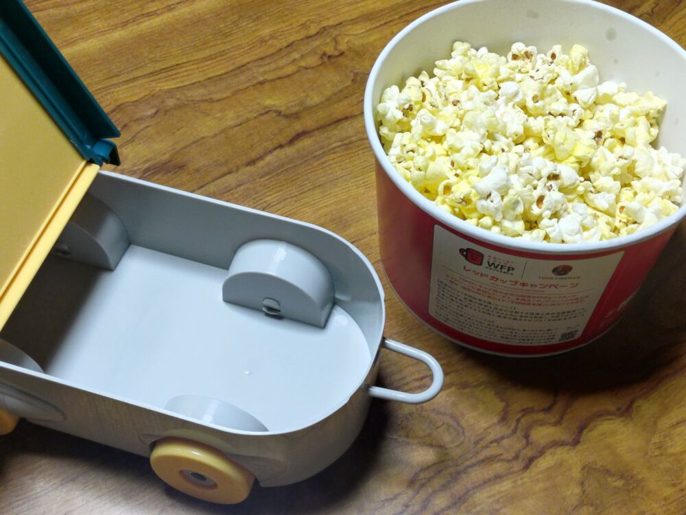 ターボエンジン付きスケートボード型ポップコーンボックスの蓋を開けたものとTOHOシネマのポップコーンMサイズ